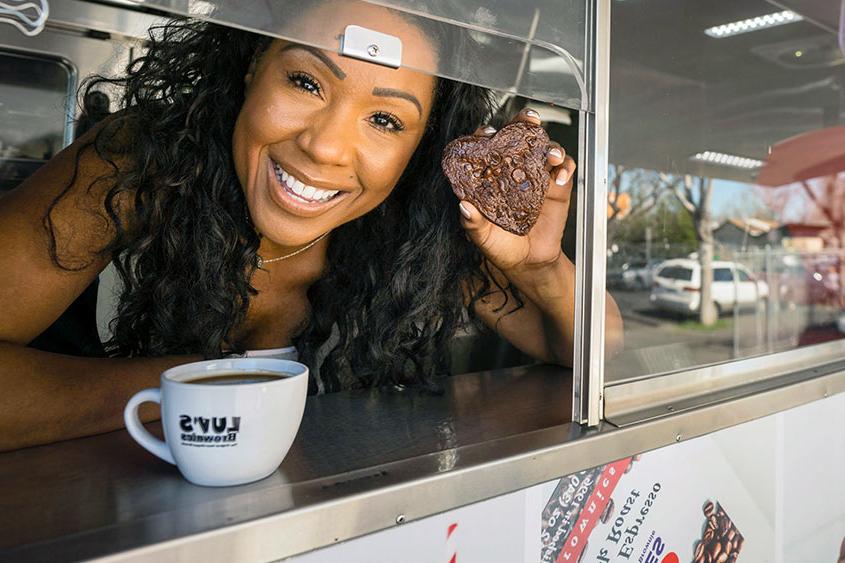 Andrea Lacy holding a brownie inside her food truck.